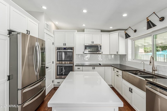 18820 N 33rd Ave, Phoenix, AZ 85027 - kitchen with stainless steel appliances, dark wood-style floors, decorative backsplash, white cabinetry, and recessed lighting