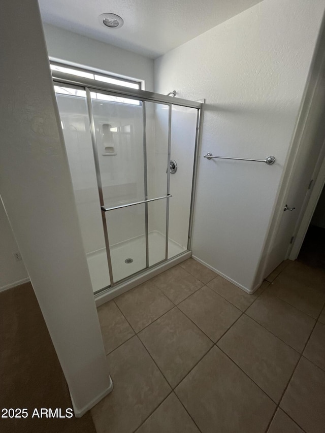 bathroom with tile patterned floors and an enclosed shower