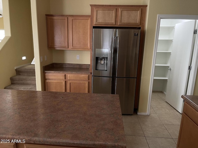 kitchen featuring light tile patterned floors and stainless steel refrigerator with ice dispenser