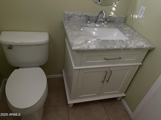 bathroom with toilet, vanity, and tile patterned floors