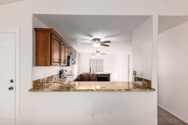 kitchen with light tile patterned flooring, sink, kitchen peninsula, stainless steel appliances, and light stone countertops