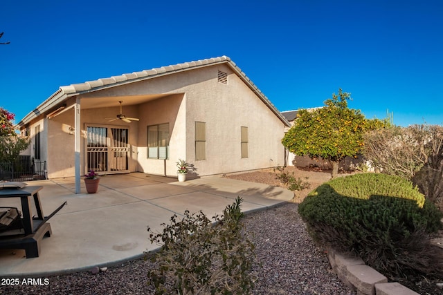 rear view of house with ceiling fan and a patio area