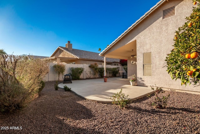 rear view of property featuring a patio, a fenced backyard, a ceiling fan, and stucco siding