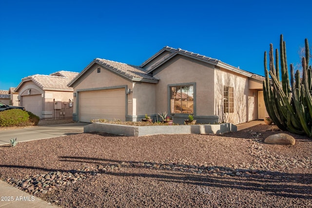 view of front of home featuring a garage, a tile roof, concrete driveway, and stucco siding