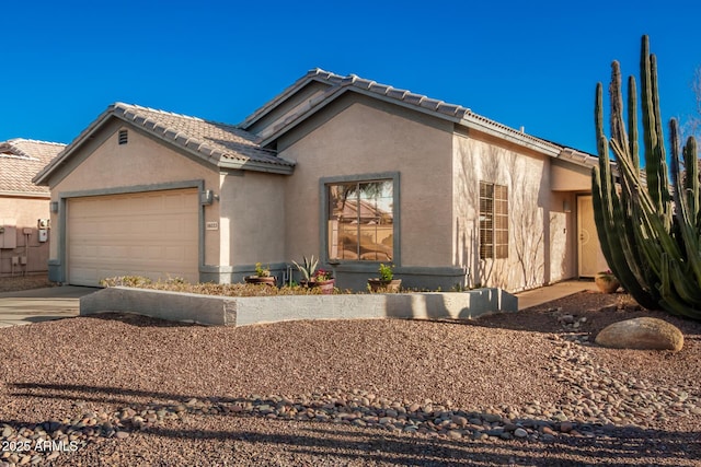 view of front of house with concrete driveway, a tile roof, an attached garage, and stucco siding