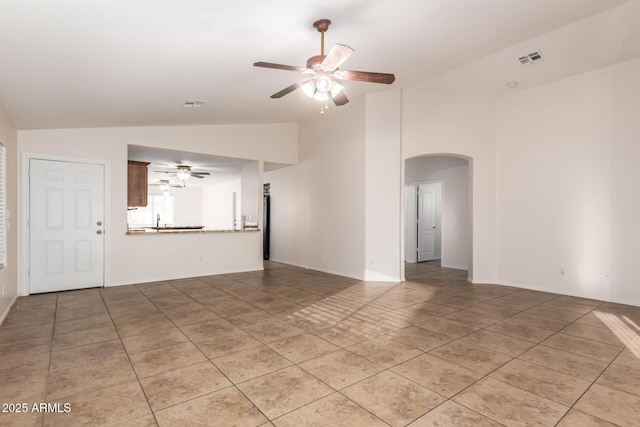 unfurnished living room with vaulted ceiling, tile patterned floors, and ceiling fan