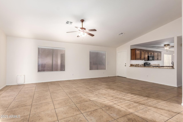 unfurnished living room featuring lofted ceiling, light tile patterned floors, and ceiling fan