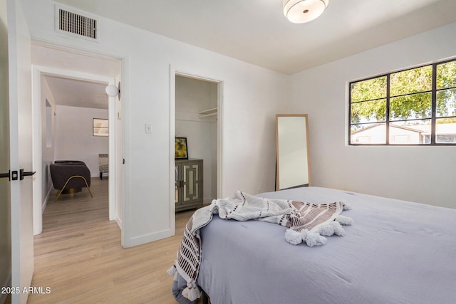 bedroom with light hardwood / wood-style floors and a closet