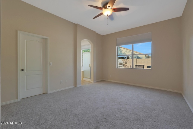 carpeted spare room featuring ceiling fan