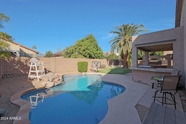 view of swimming pool featuring a patio and an outdoor bar