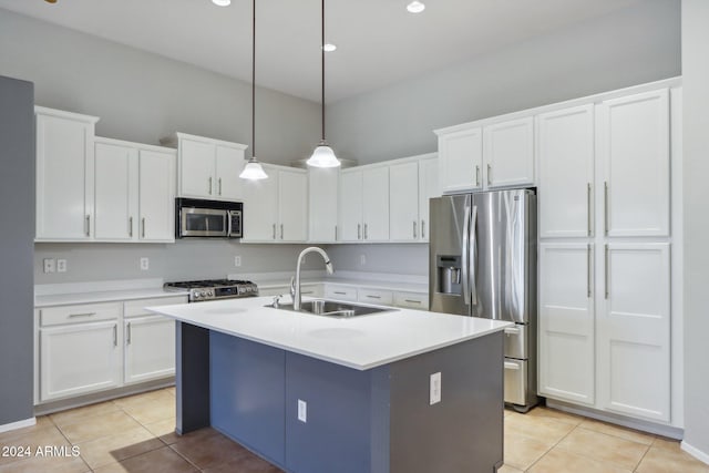 kitchen with sink, hanging light fixtures, a center island with sink, white cabinets, and appliances with stainless steel finishes