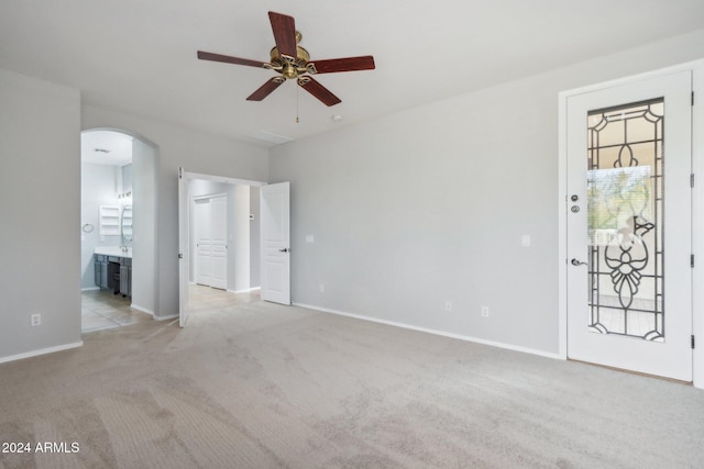 unfurnished living room featuring ceiling fan and light carpet