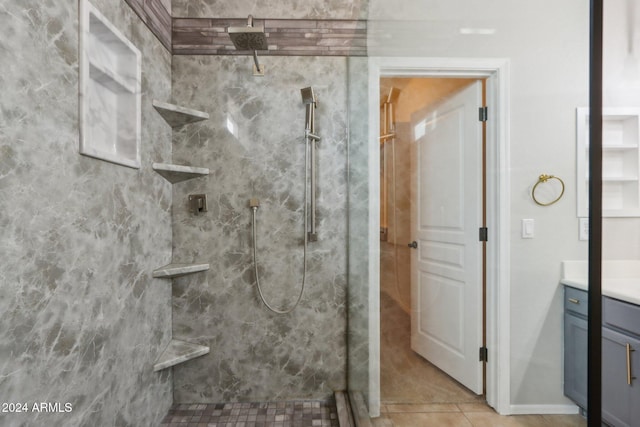 bathroom with tile patterned flooring, vanity, and tiled shower