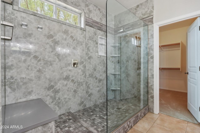 bathroom featuring tile patterned flooring and tiled shower