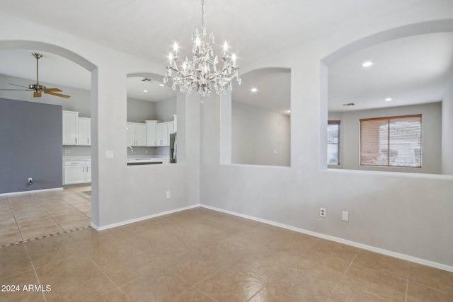 empty room with sink, light tile patterned floors, and ceiling fan with notable chandelier