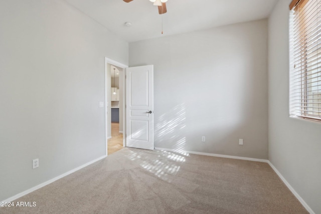 unfurnished room with ceiling fan and light colored carpet