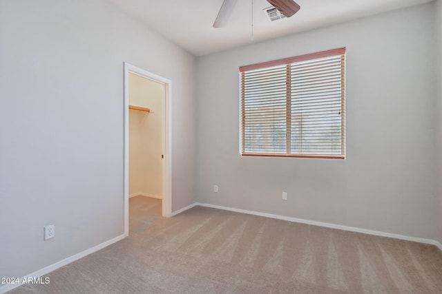 unfurnished room featuring ceiling fan and light carpet