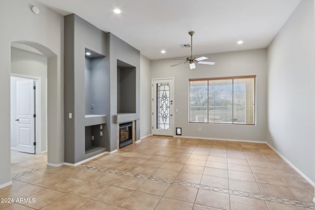 unfurnished living room with ceiling fan and light tile patterned floors