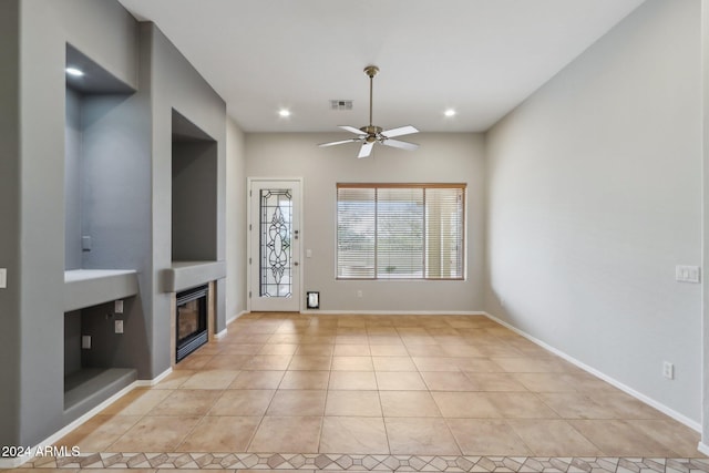 unfurnished living room featuring ceiling fan and light tile patterned floors