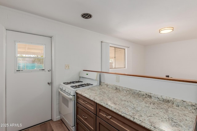 10012 N 16th Dr, Phoenix, AZ 85021 - kitchen with white gas range, light wood-style flooring, and light stone counters
