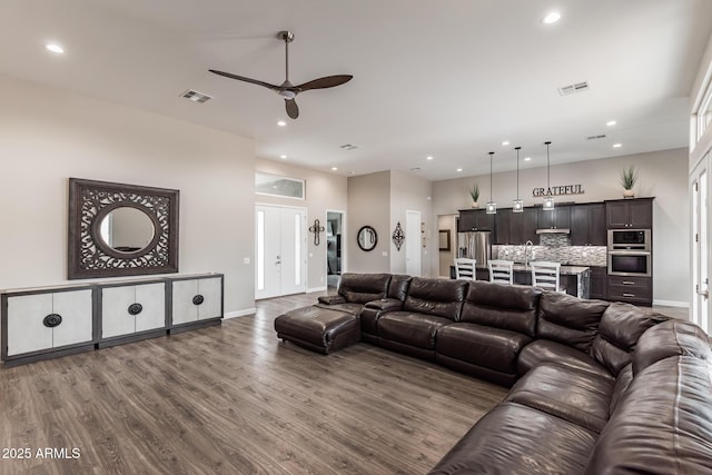 living room with hardwood / wood-style floors, ceiling fan, and sink