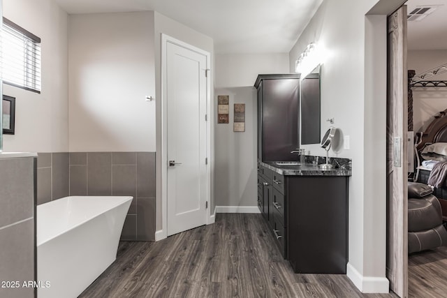 bathroom with a bathing tub, vanity, tile walls, and hardwood / wood-style flooring