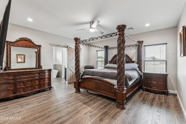 bedroom featuring a barn door, hardwood / wood-style flooring, and ceiling fan