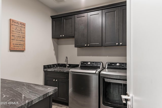 clothes washing area with cabinets, independent washer and dryer, and sink