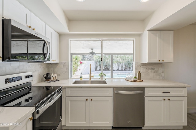 kitchen featuring light countertops, appliances with stainless steel finishes, a sink, and white cabinetry