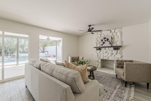 living room with a ceiling fan and a fireplace