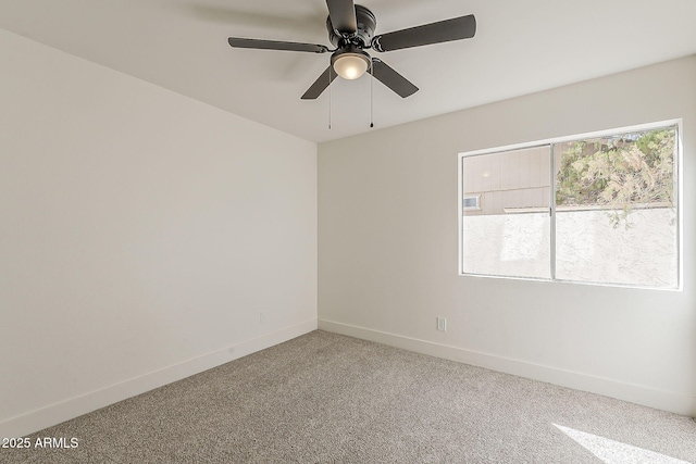 spare room with ceiling fan, carpet, and baseboards