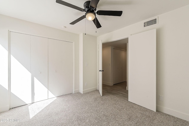 unfurnished bedroom with baseboards, visible vents, a ceiling fan, carpet flooring, and a closet