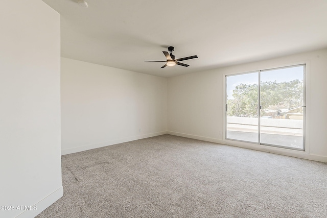 carpeted empty room featuring a ceiling fan and baseboards