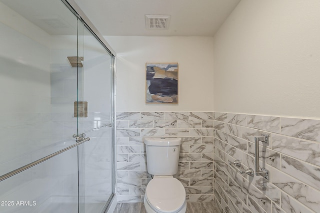 full bath with a stall shower, visible vents, tile walls, and toilet