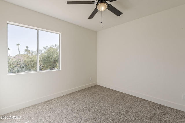 carpeted spare room with baseboards and a ceiling fan