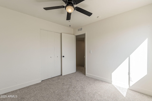 unfurnished bedroom featuring carpet, baseboards, ceiling fan, and a closet