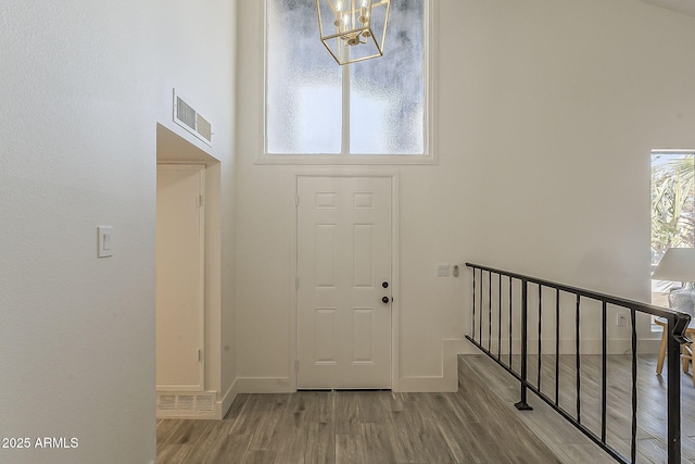 foyer entrance featuring plenty of natural light, wood finished floors, and visible vents