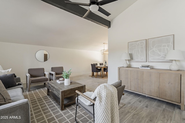 living area featuring ceiling fan, baseboards, vaulted ceiling, and wood finished floors