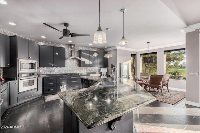 kitchen with a large island, sink, stainless steel appliances, and decorative light fixtures