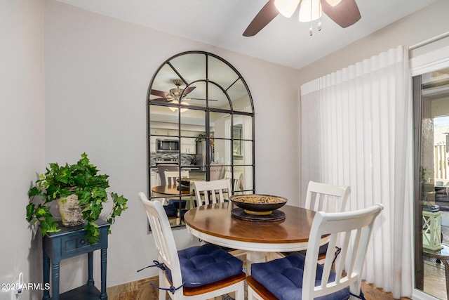 dining space featuring wood-type flooring and ceiling fan