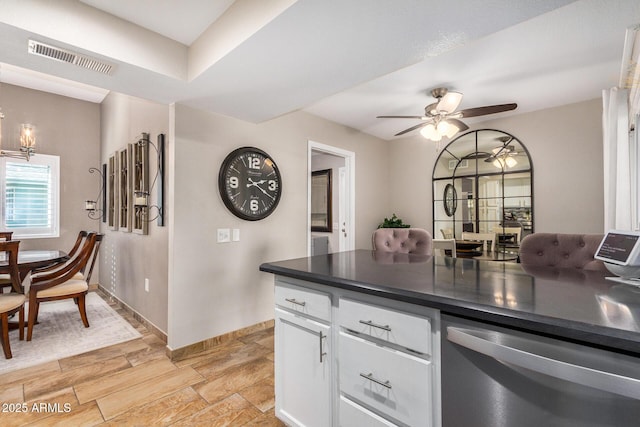 kitchen with ceiling fan with notable chandelier, stainless steel dishwasher, light hardwood / wood-style floors, and white cabinets