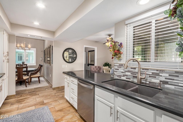 kitchen with sink, a raised ceiling, dishwasher, decorative backsplash, and white cabinets