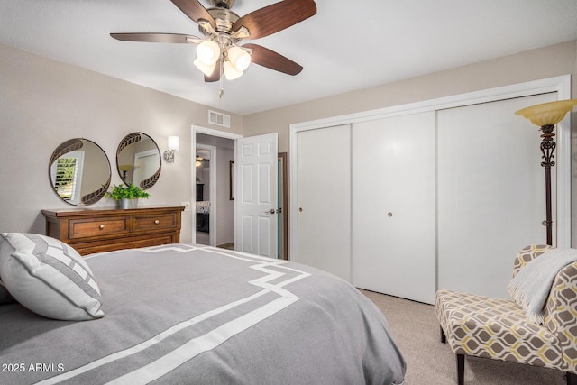 bedroom featuring light carpet, ceiling fan, and a closet