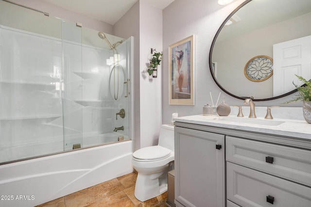 full bathroom with vanity, combined bath / shower with glass door, and toilet