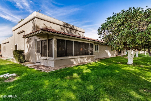 rear view of house with a sunroom and a yard