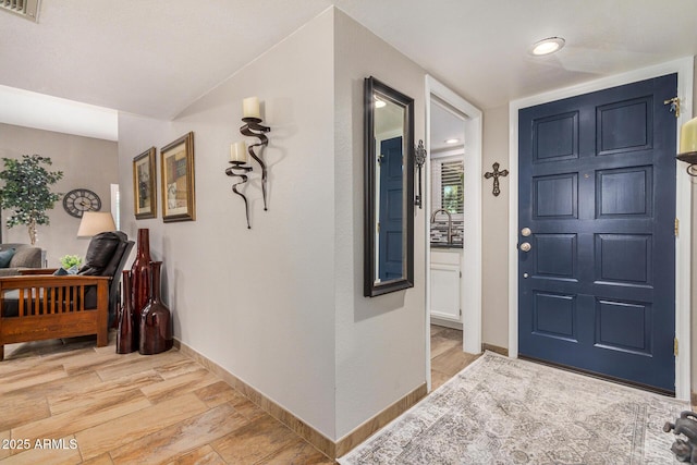 entryway featuring sink and light wood-type flooring