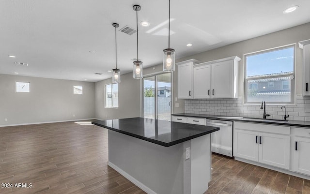 kitchen featuring dishwasher, sink, hanging light fixtures, and white cabinets