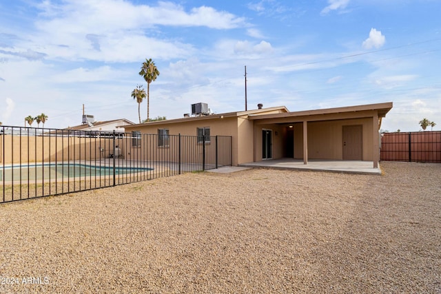 back of house featuring a fenced in pool, a patio area, and central AC