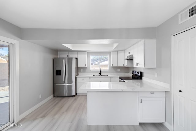 kitchen featuring a wealth of natural light, white cabinets, stainless steel appliances, and light wood-type flooring