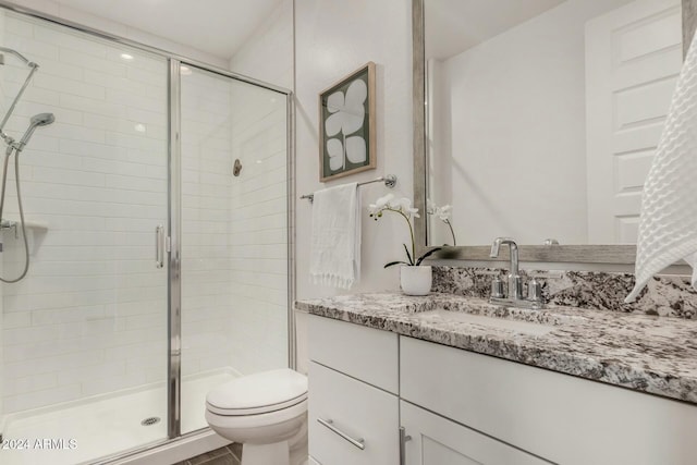 bathroom with vanity, toilet, and an enclosed shower